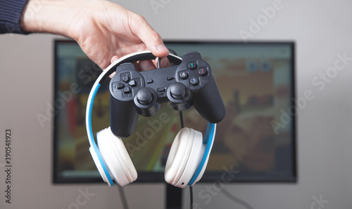 Gamer holding joystick and headphones.