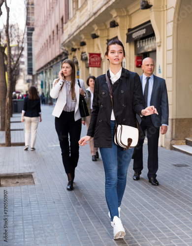 Men and women in business suits walking down street