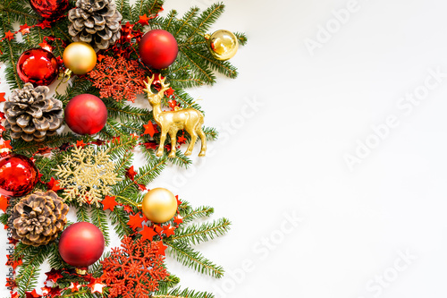 Mockup of natural green branches of a Christmas tree with cones, balls, snowflakes, and tinsel on the left on a white background. Flat lay, top view, copy space. Christmas, New Year concept