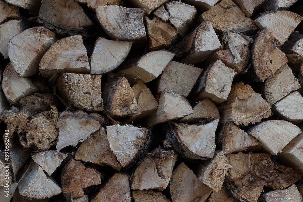 Firewood for the winter, stacks of firewood, a pile of firewood close-up. Fuel. Preparation of firewood for the winter. Woodpile background, stacks of chopped firewood.