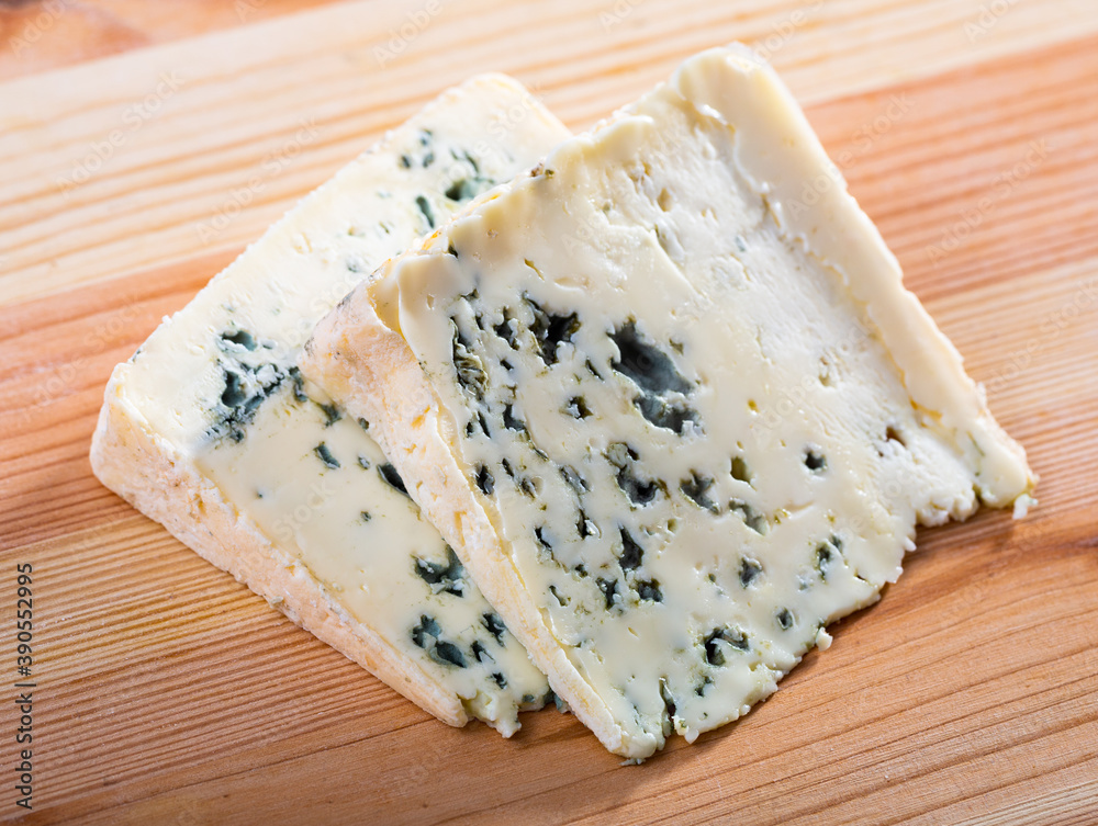 Image of slices of blue cheese with mold at plate, nobody