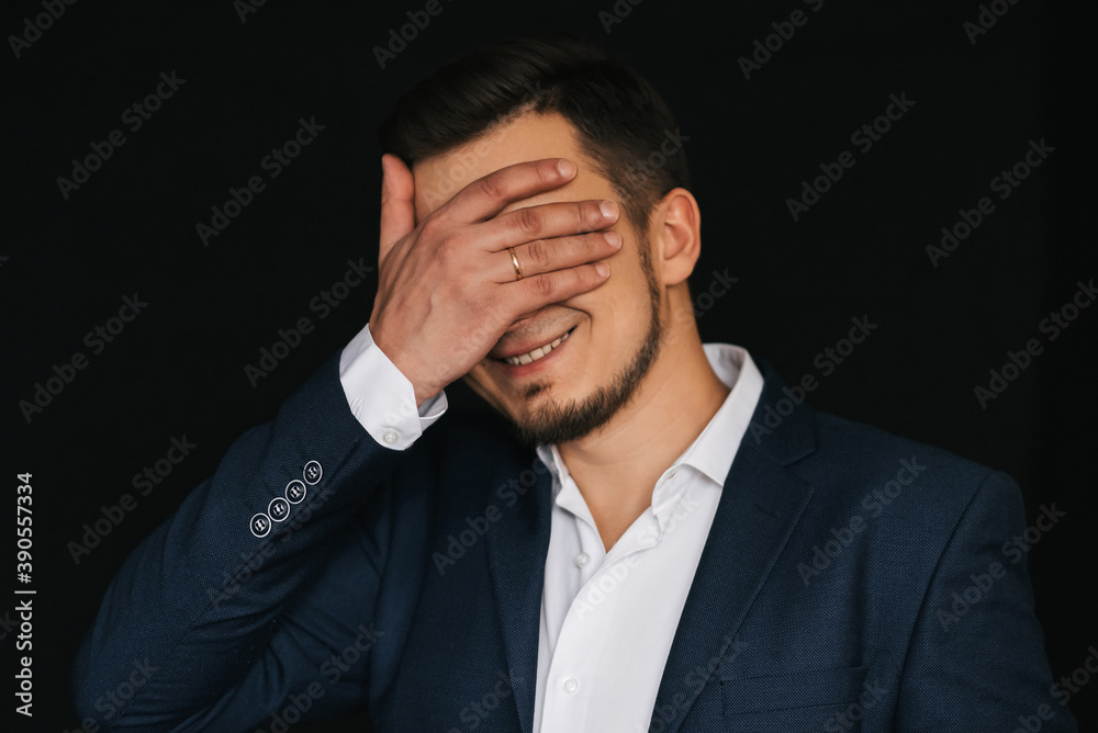 Happy bearded man with a smile covers face with hand Happy bearded man with a smile covers face with hand