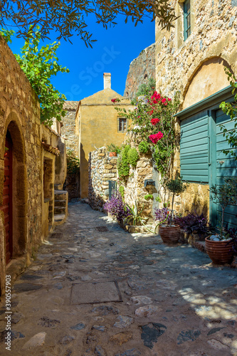 Traditional architecture with  narrow  stone street and a colorfull bougainvillea in  the medieval  castle of Monemvasia  Lakonia  Peloponnese  Greece.