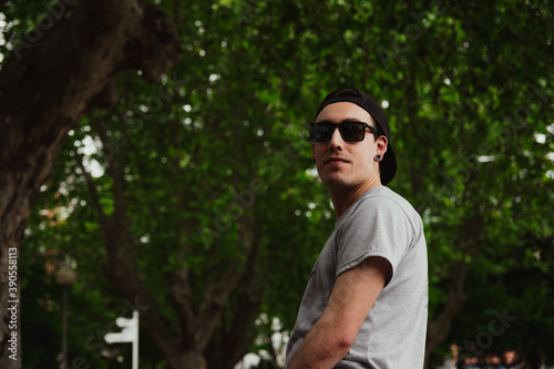 Handsome young man dressed in casual clothes outdoors, sunglasses, copy space, social media, smile, happiness, recreation concept, man advertising