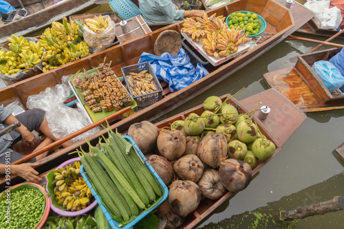 Damnoen Saduak Floating Market or Amphawa. Local people sell fruits, traditional food on boats in canal, Ratchaburi District, Thailand. Famous Asian tourist attraction. photo