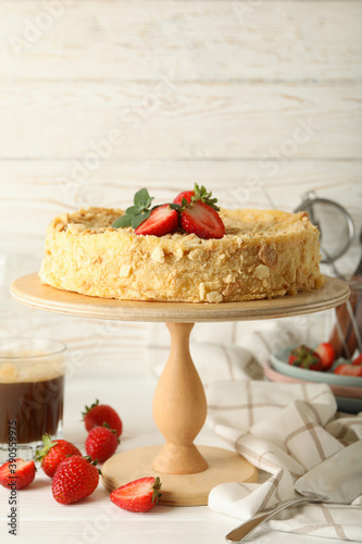 Concept of tasty lunch with stand with Napoleon cake with strawberry