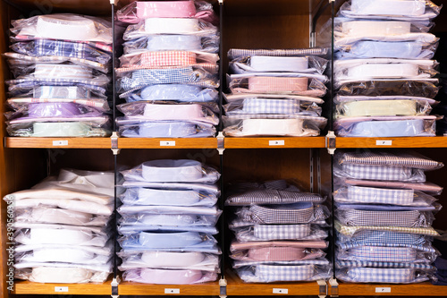 Clothing store. Shelves with shirts of different sizes. High quality photo