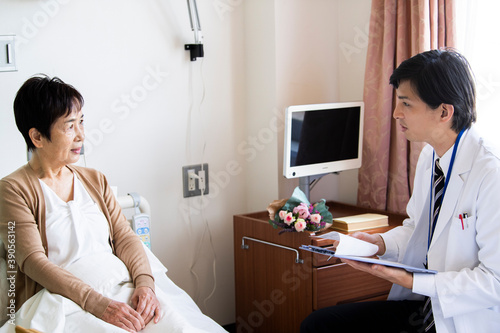 回診に来た男性医師と会話をする女性の患者
