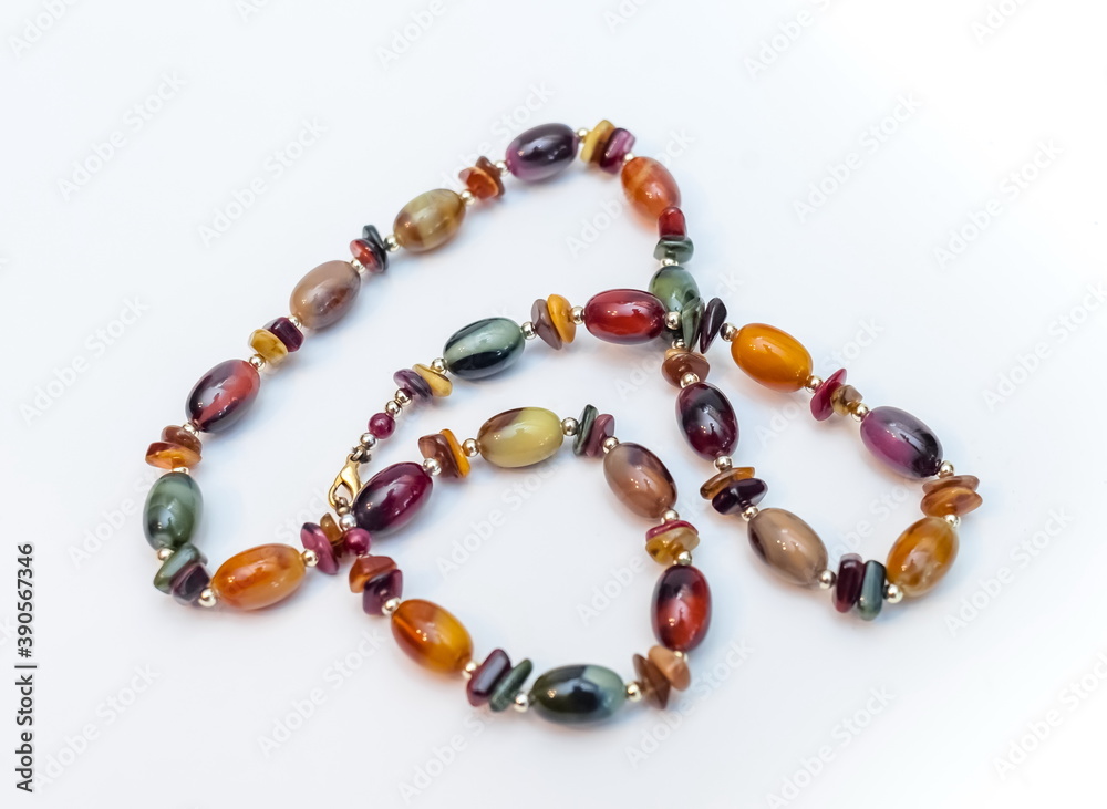 Purchased beads of colored stones close-up on a white background Purchased beads of colored stones close-up on a white background