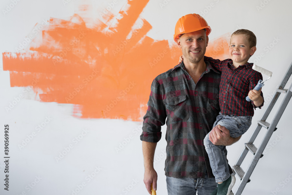 © Andrii Lysenko - Happy young family is renovating their house, the father is holding his son in his arms.