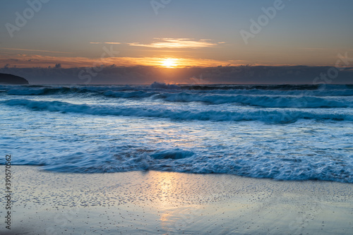 Sunrise seascape with light cloud, waves and rocks