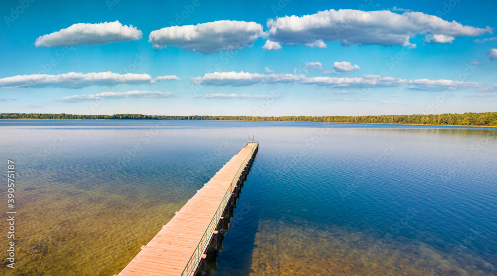 Wooden pier on Pisochne Lake. Sunny morning scene of Shatsky National Park, Volyn region, Ukraine, Europe. Beauty of nature concept background..