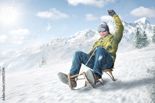 Happy man riding on a sled in winter photo