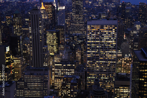 New york city lights of business offices in Manhattan at dusk or dawn. Urban cityscape at twilight. Concept of overpopulated megapolis. USA/America. Home office concept during coronavirus. 