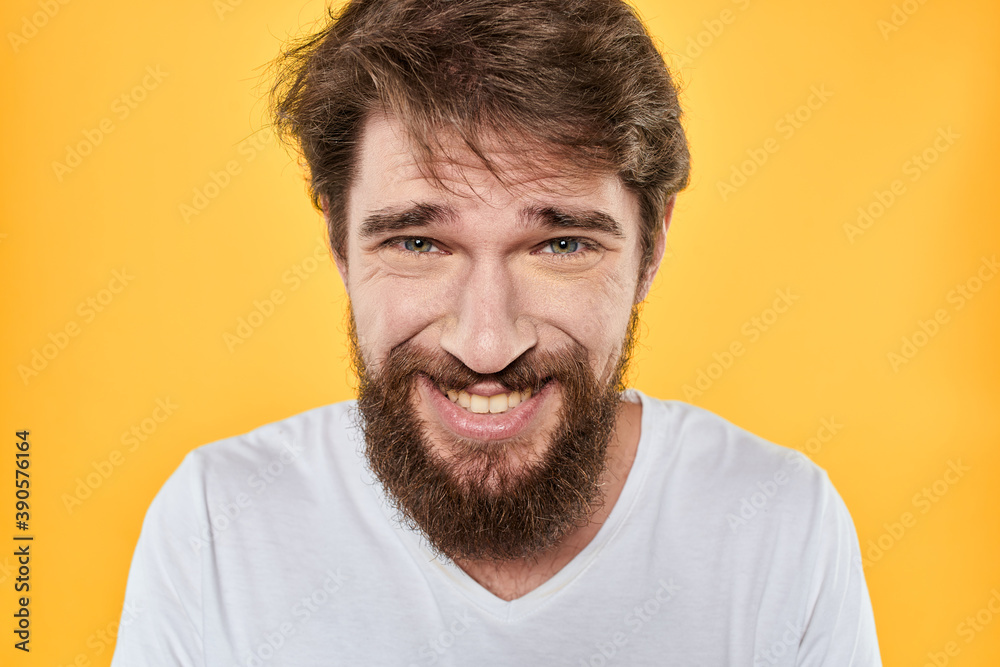 Man with emotional expression white t-shirt close-up studio yellow background Man with emotional expression white t-shirt close-up studio yellow background