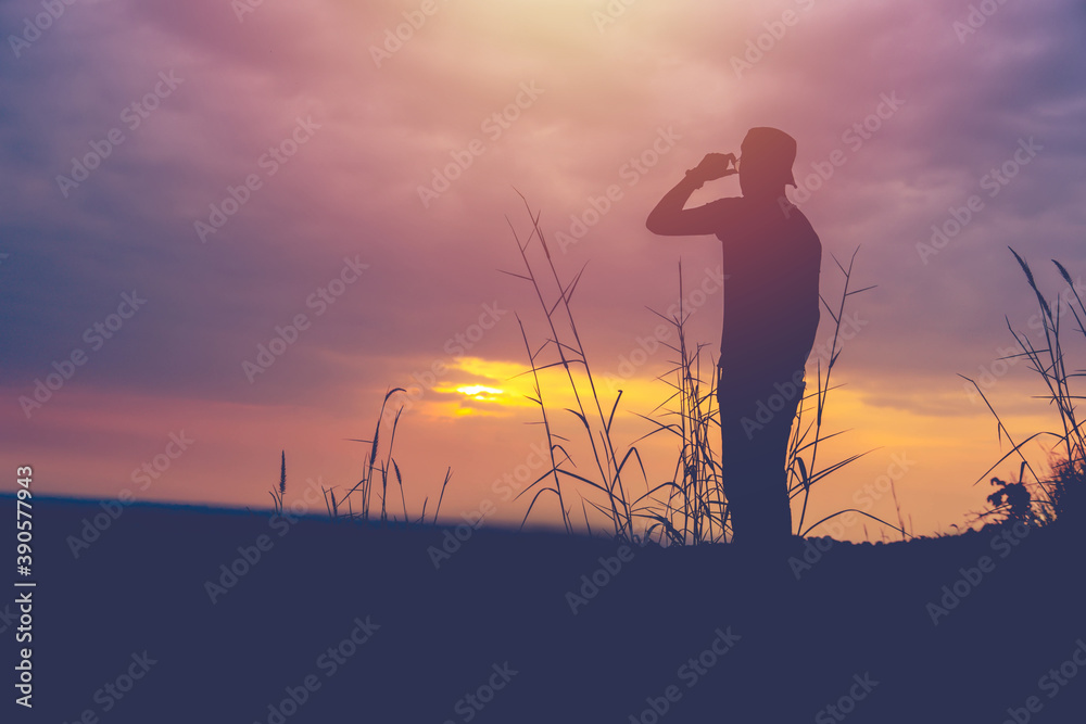 silhouette of man standing on  mountain at sunset or sunrise time. success .