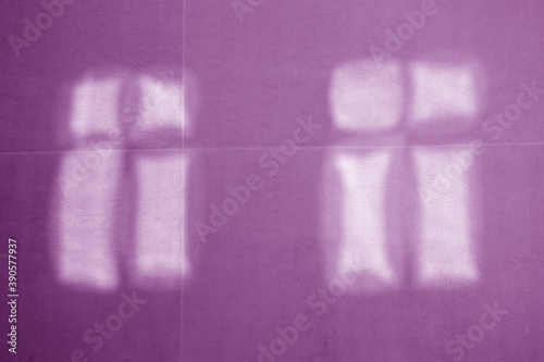 Reflection of two windows on violet cement wall.