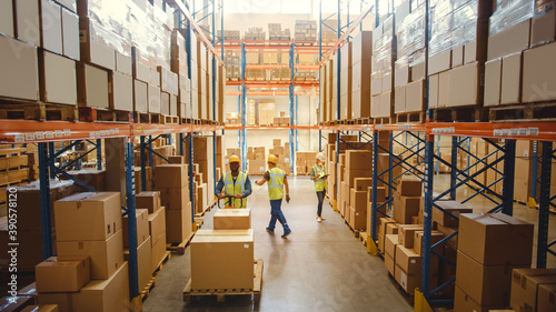 Retail Warehouse full of Shelves with Goods in Cardboard Boxes, Workers Scan and Sort Packages, Move Inventory with Pallet Trucks and Forklifts. Product Distribution Logistics Center. Elevated Shot photo