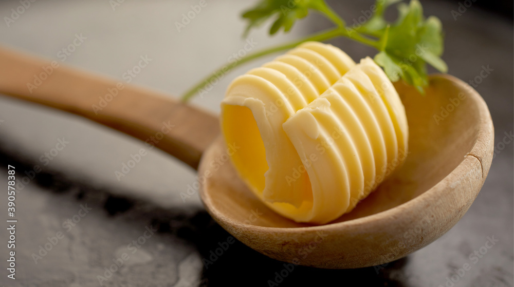 Single elegant ridged butter curl in wooden spoon Single elegant ridged butter curl in wooden spoon