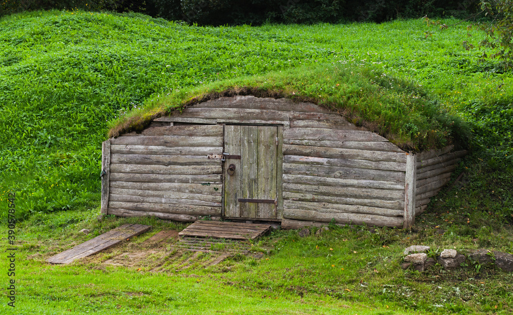 Old wooden cellar in hill covered with grass Old wooden cellar in hill covered with grass