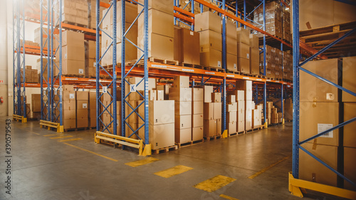 Large Retail Warehouse full of Shelves with Goods in Cardboard Boxes and Packages. Logistics, Sorting and Distribution Facility for further Product Delivery. photo