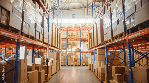 Retail Warehouse full of Shelves with Goods in Cardboard Boxes and Packages. Logistics, Sorting and Distribution Facility for Product Delivery.