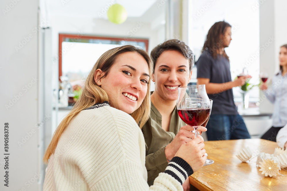Fototapeta premium Zwei Frauen als Freundinnen stoßen auf Feier mit Rotwein an