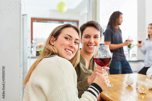 Zwei Frauen als Freundinnen stoßen auf Feier mit Rotwein an