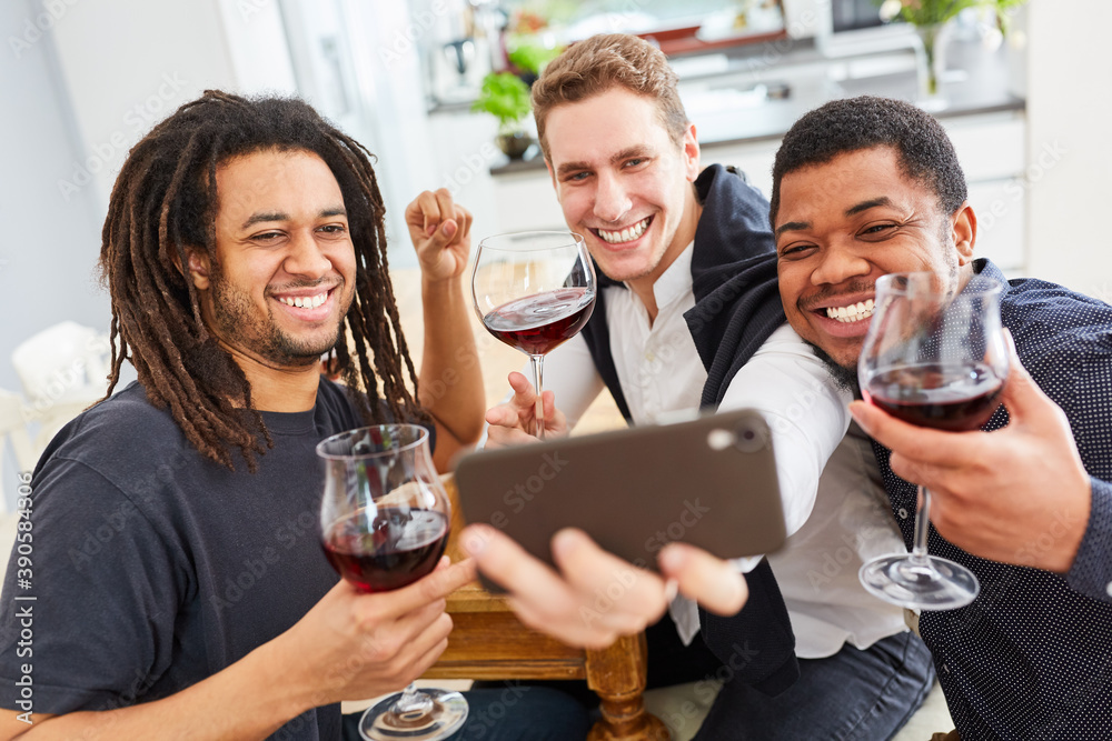 Lachende Männer als Freunde machen Selfie mit Smartphone bei Glas Rotwein Lachende Männer als Freunde machen Selfie mit Smartphone bei Glas Rotwein