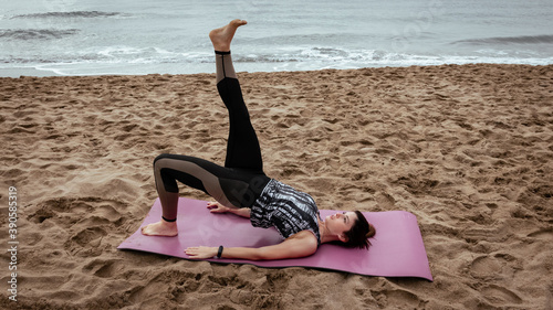 Young beautiful woman working out at the beach in the morning
