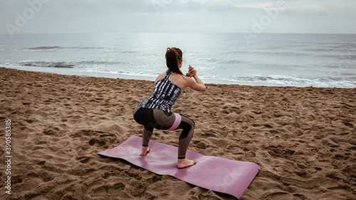 Young beautiful woman working out at the beach in the morning