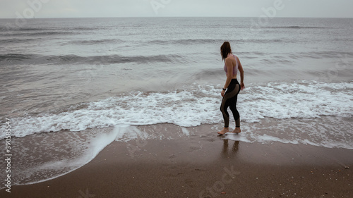 Young beautiful woman walking at the beach after working out wearing sporty clothes