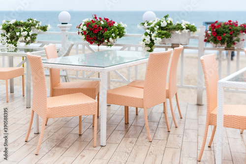 Empty tables and chairs of a restaurant on a terrace overlooking the sea. Cafe with sea view. Nice place to eat with seaview. Selective focus. © Magryt