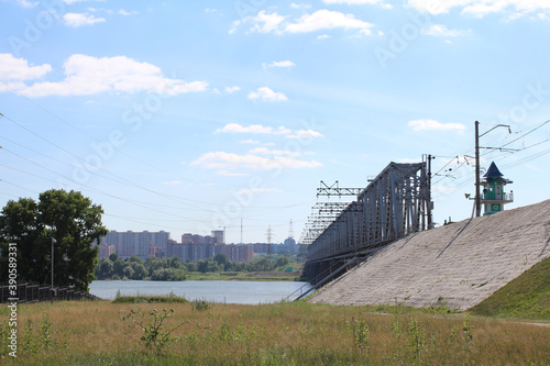 railway bridge over the river with embankment at the reservoir city landscape