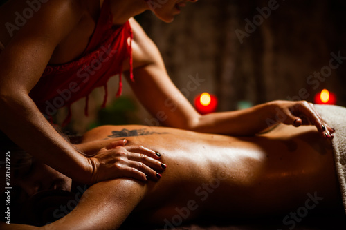 Deep tissue massage on the woman's middle back on erector spinae muscles photo