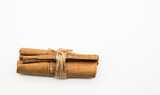 Cinnamon sticks tied with a cord on a white background.