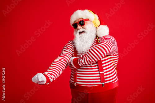 Portrait of his he handsome bearded fat overweight cheerful cheery dreamy Santa fan meloman listening single sound dancing having fun isolated bright vivid shine vibrant red color background © deagreez
