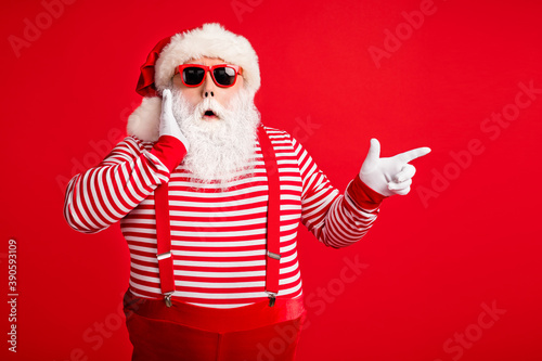 Portrait of his he nice handsome attractive wondered amazed bearded fat gray-haired Santa demonstrating copy space novelty look idea isolated on bright vivid shine vibrant red color background © deagreez