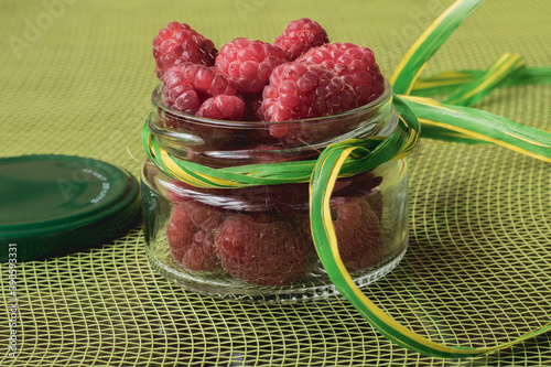 Raspberries are in the glass jar