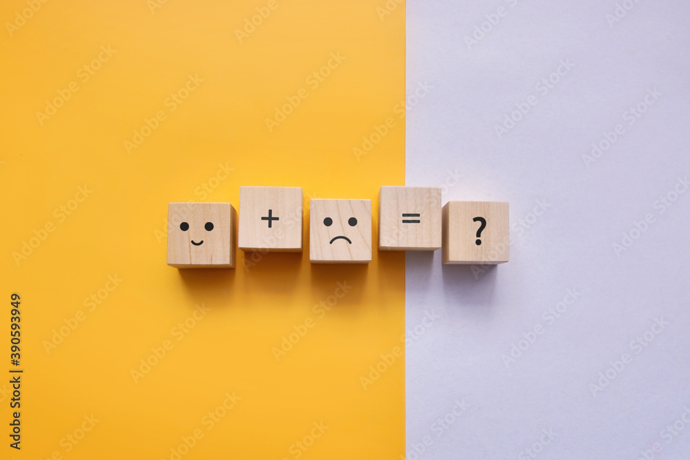 Wooden cubes with the image of a sad and joyful face. happy and joyful person together Wooden cubes with the image of a sad and joyful face. happy and joyful person together