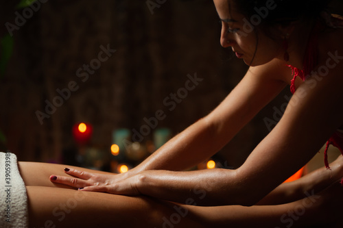 Beautiful young woman getting feet massage treatment at spa