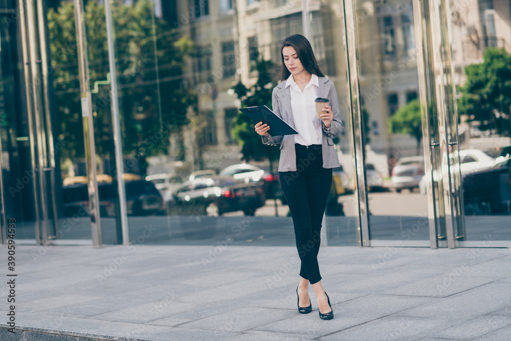 Full size photo of young attractive businesswoman hold look clipboard coffee break outdoors in downtown