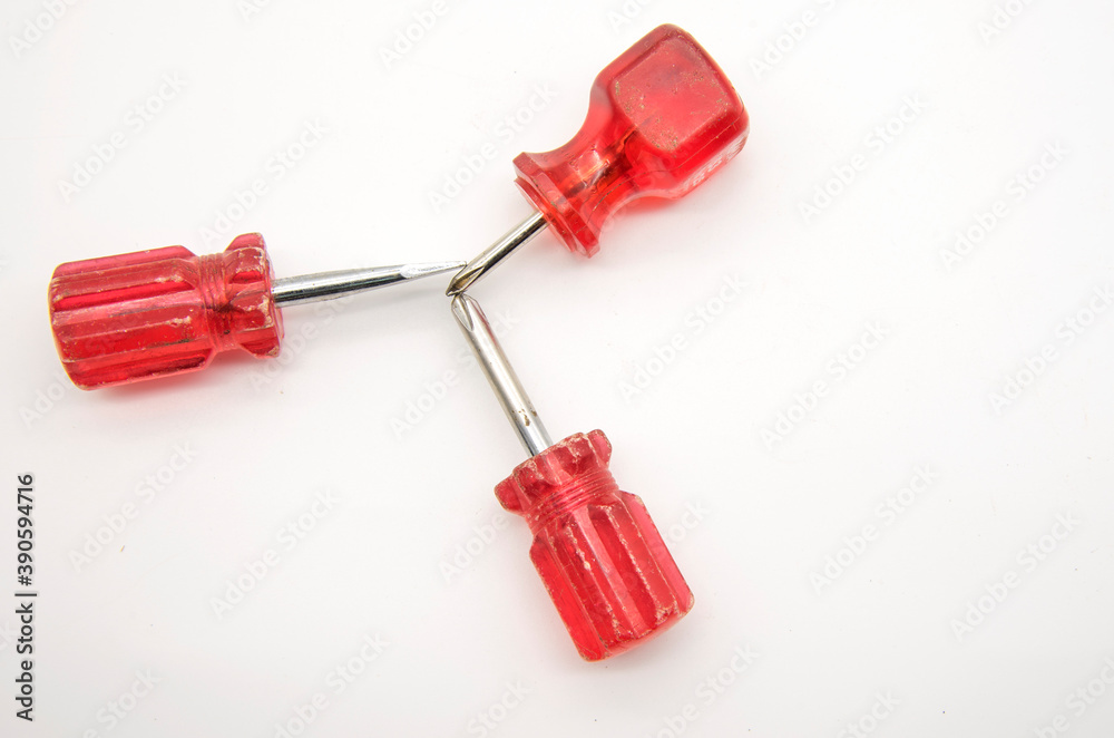 Three small screwdrivers with red handles on a white background. Three small screwdrivers with red handles on a white background.
