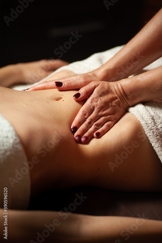 Beautiful young woman having visceral massage in spa center