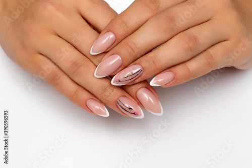 Extension of nails. Wedding french white manicure with painted flowers on sharp long nails. Close-up on a white background.