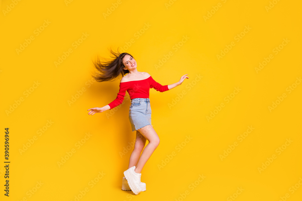 Full body size photo of charming pretty young girl aired hair dance party celebrating wear shirt open shoulders denim mini skirt sneakers isolated bright yellow color background Full body size photo of charming pretty young girl aired hair dance party celebrating wear shirt open shoulders denim mini skirt sneakers isolated bright yellow color background