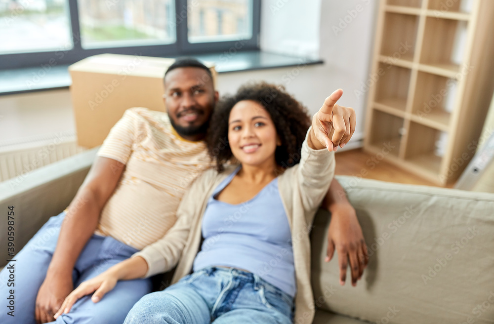 moving, people, repair and real estate concept - happy african american couple with cardboard boxes sitting on sofa at new home moving, people, repair and real estate concept - happy african american couple with cardboard boxes sitting on sofa at new home