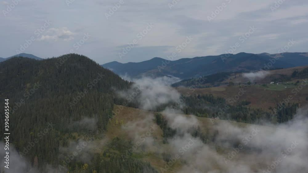 Beautiful aerial view of the slopes and tops of the Carpathian Mountains. A drone flight over low clouds covering dense autumn forest and mountain slopes. Beautiful aerial view of the slopes and tops of the Carpathian Mountains. A drone flight over low clouds covering dense autumn forest and mountain slopes.
