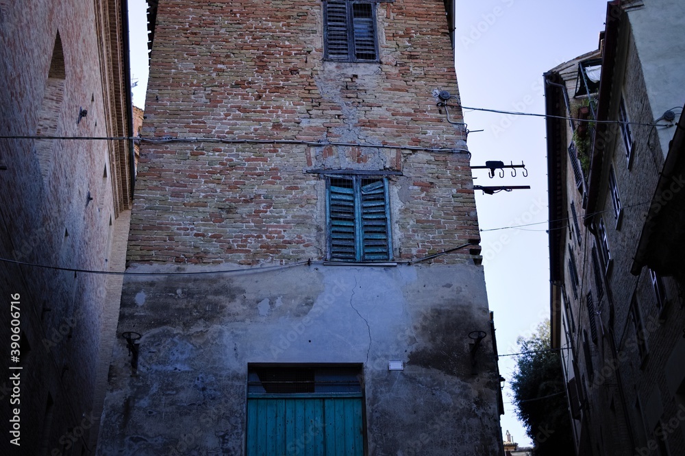 A broken window of an abandoned building in the streets of an italian village (Corinaldo, Marche, Italy)