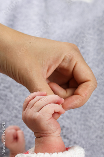 infant, a newborn baby holding a mother's finger closeup